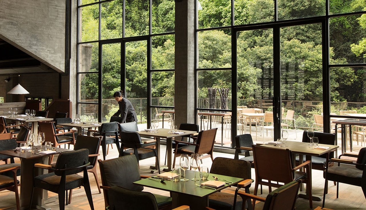 Exterior view of Yangshuo Sugar House resort, showing the preserved 1960s sugar mill architecture against Karst mountains